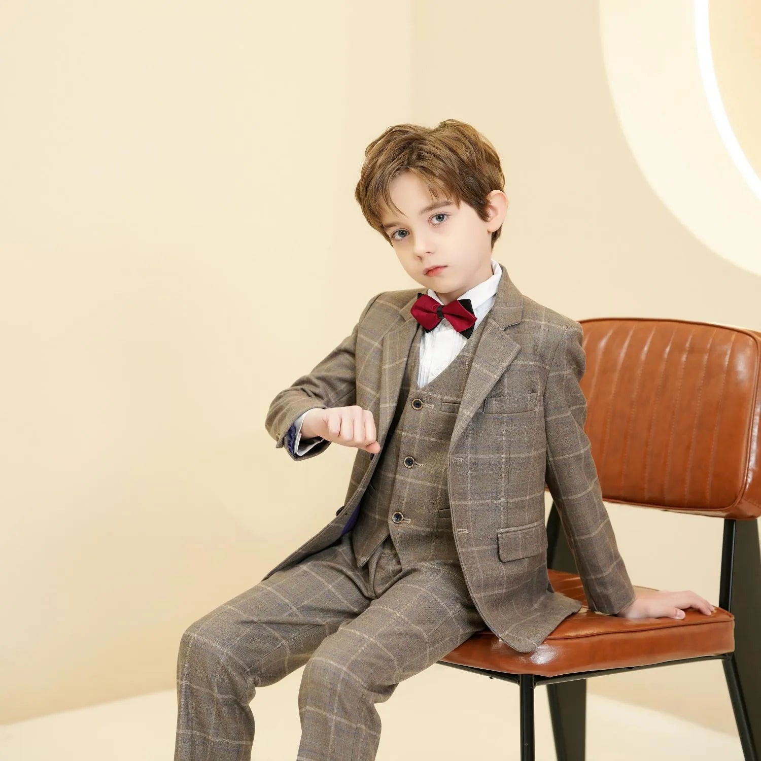 Khaki plaid boys 5-piece suit: Seated pose with red bow tie & vest detail