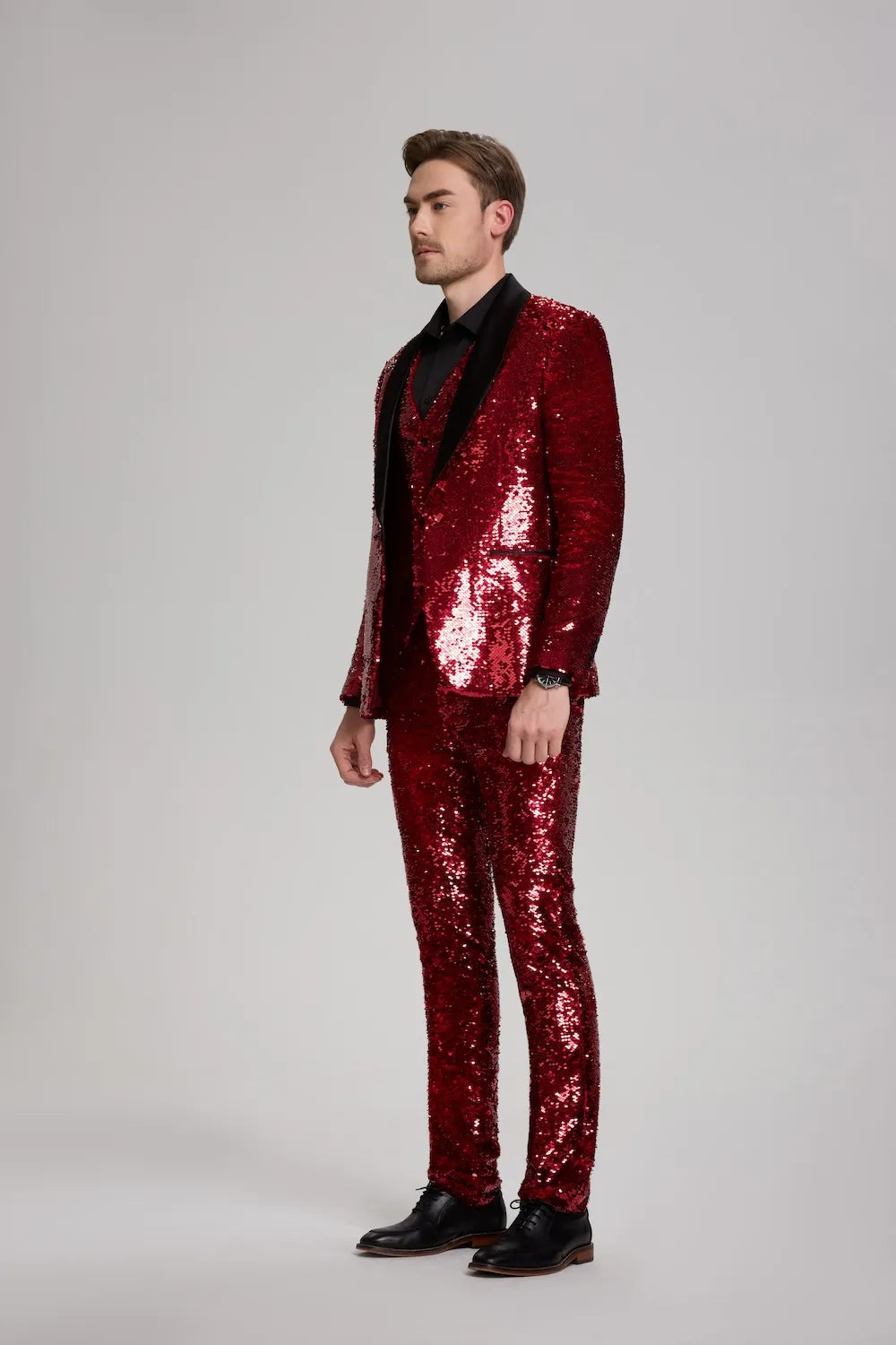 Close-up of red sequins and peak lapel on men's sparkle tuxedo jacket.