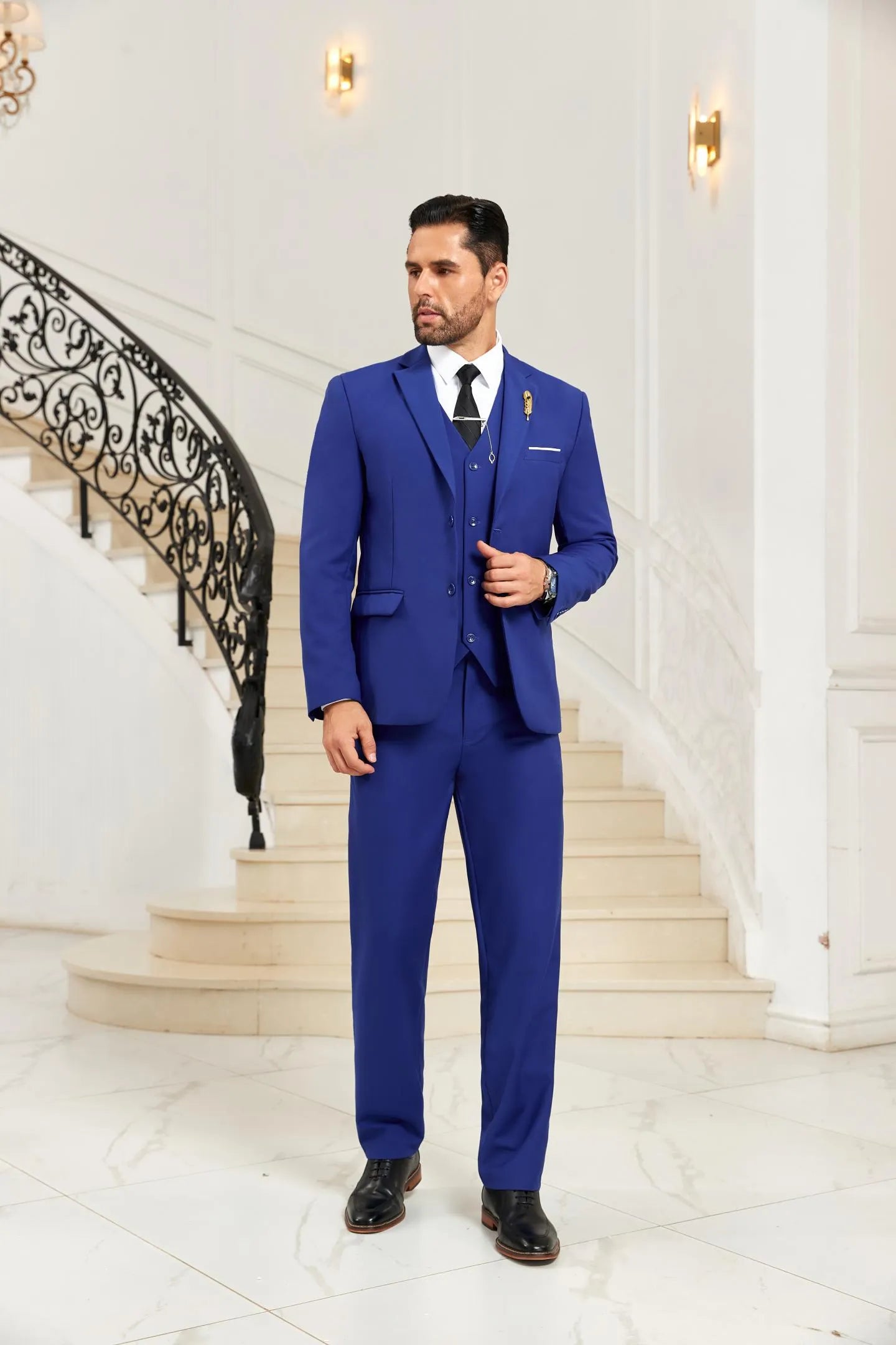 Man wearing blue 3 piece men's suit with blazer, vest, and pants, styled for wedding and formal occasions, side pose view