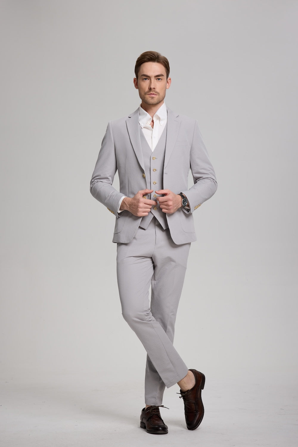 Full-body view of man in grey 3-piece seersucker suit with white shirt