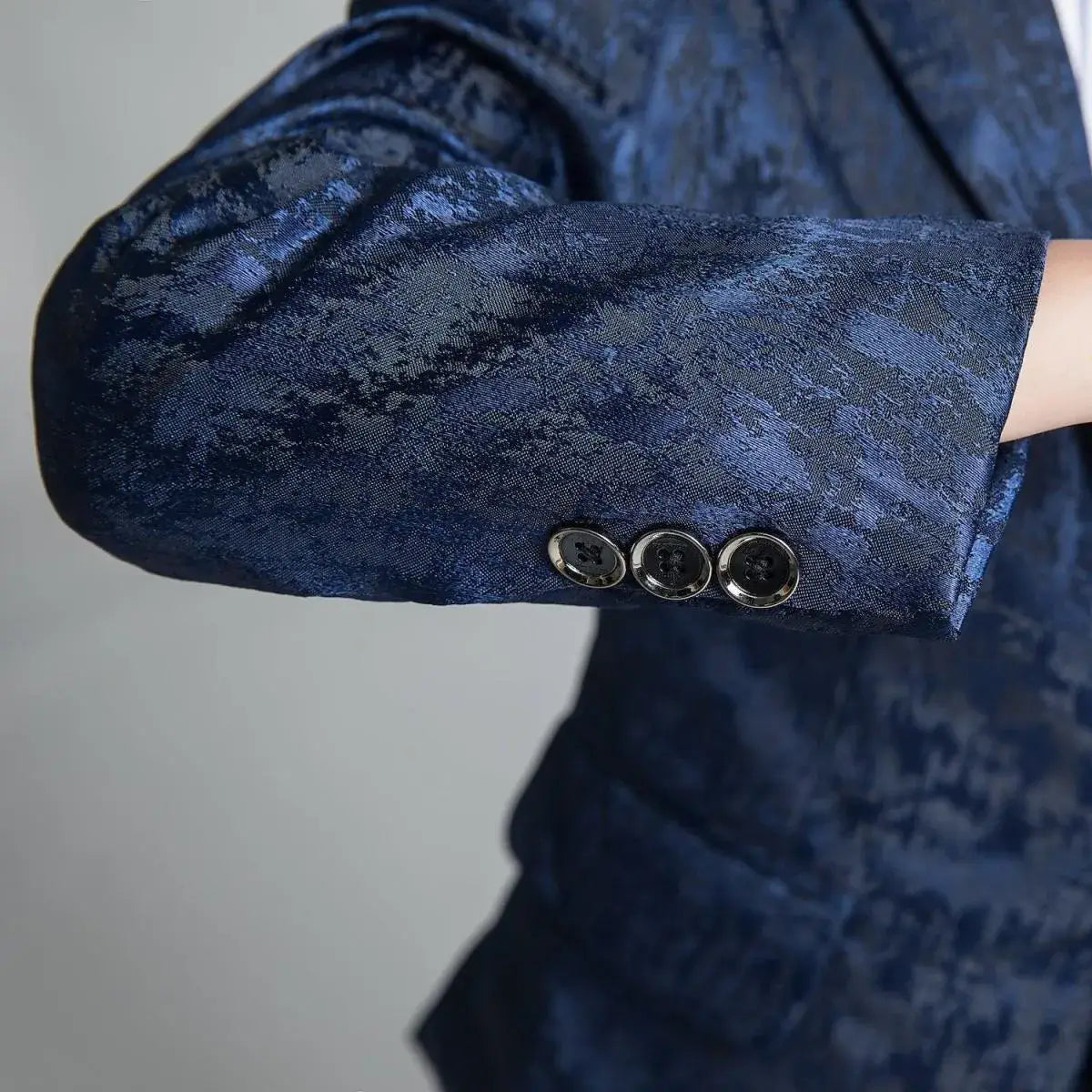 Close-up of navy floral suit sleeve with three-button cuff detail on boys' slim fit formalwear