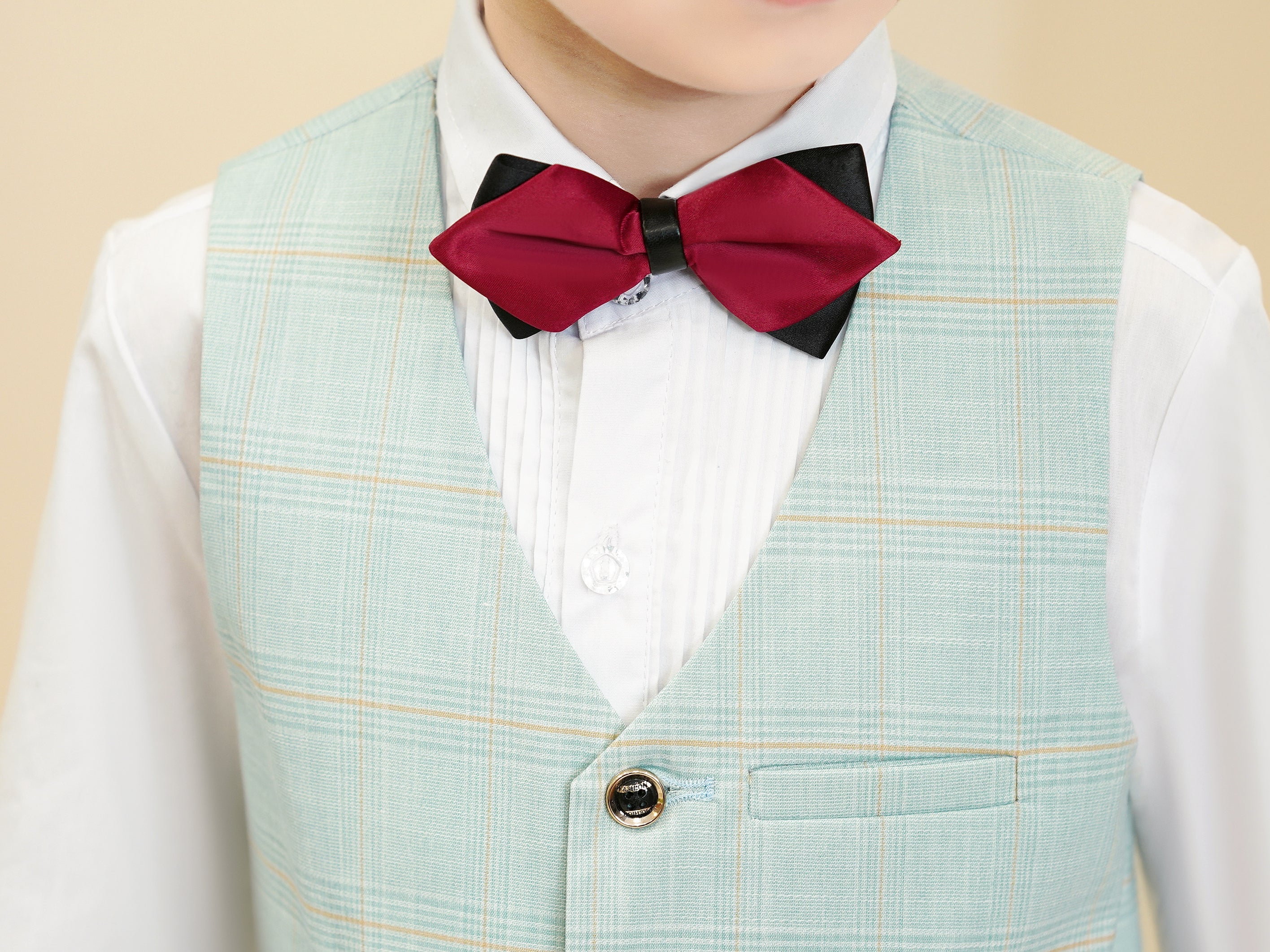 Close-up of mint green plaid boys vest with buttons and pocket detailing