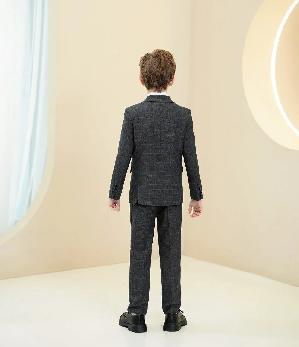 Rear view of boy in black plaid tuxedo suit with notch lapel and tailored pants for prom or formal event