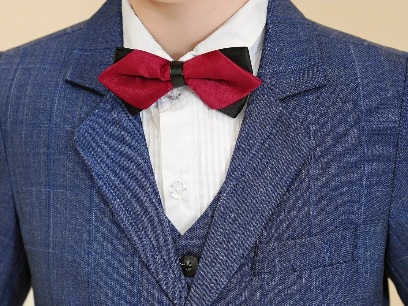 Boys formal plaid suit: Close-up of red bow tie on blue checked lapel