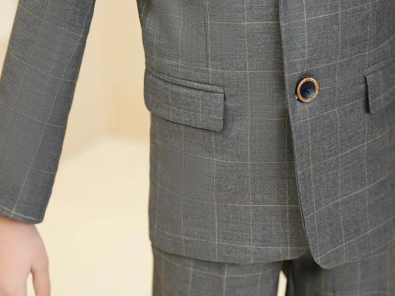 Grey plaid boys 5-piece suit: Close-up of blazer front with wooden-trimmed button & checked pattern
