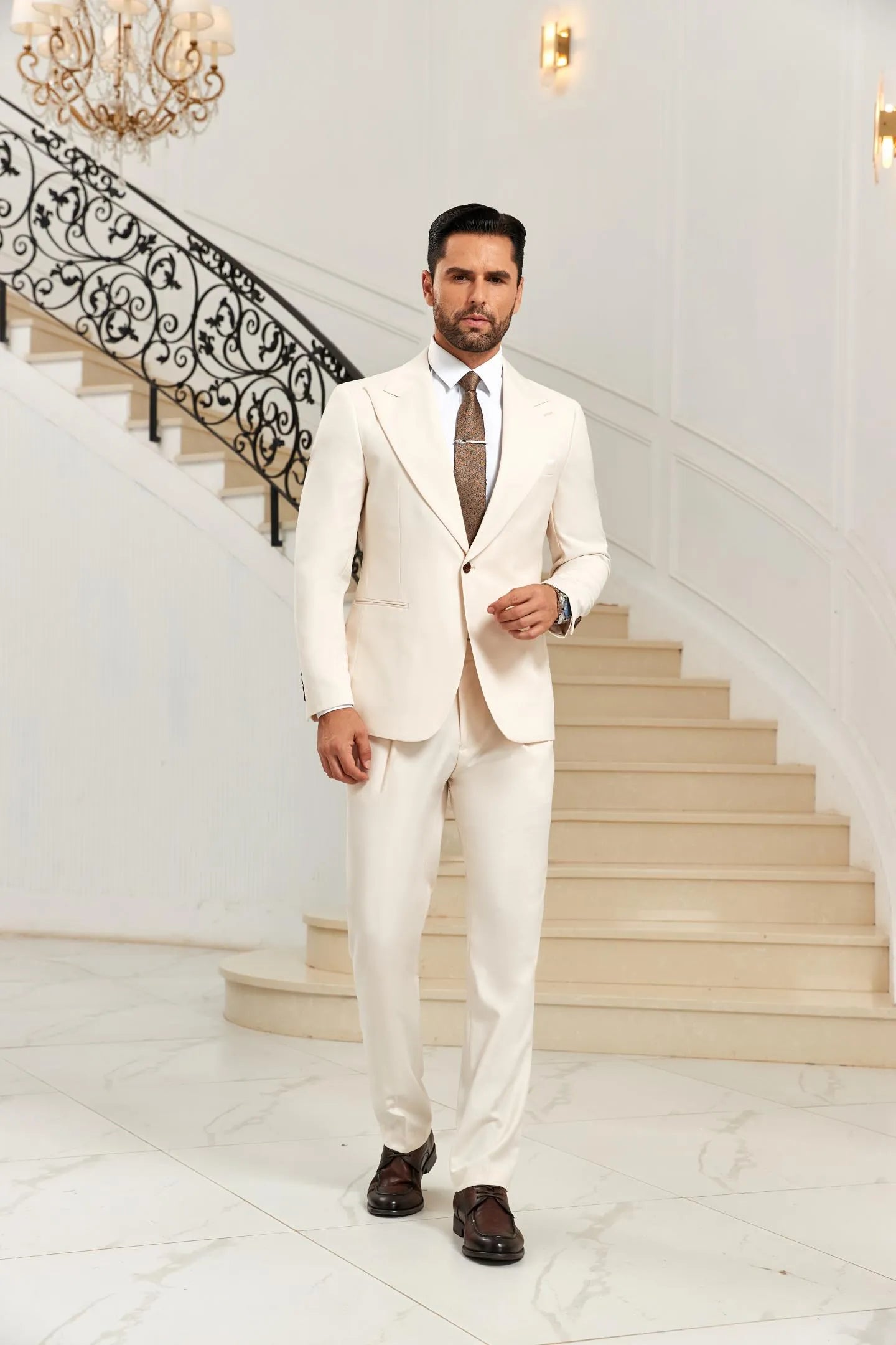 White 2 piece men's suit with peak lapel blazer and pants, styled with brown tie, front view formal wedding outfit.