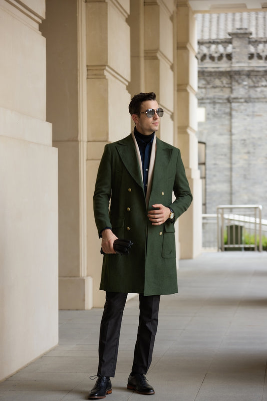Full body view of men’s green overcoat styled with gloves and formal pants
