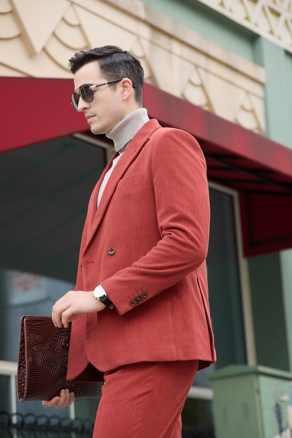 Side walking pose in red corduroy blazer – brown clutch and layered wristwatch