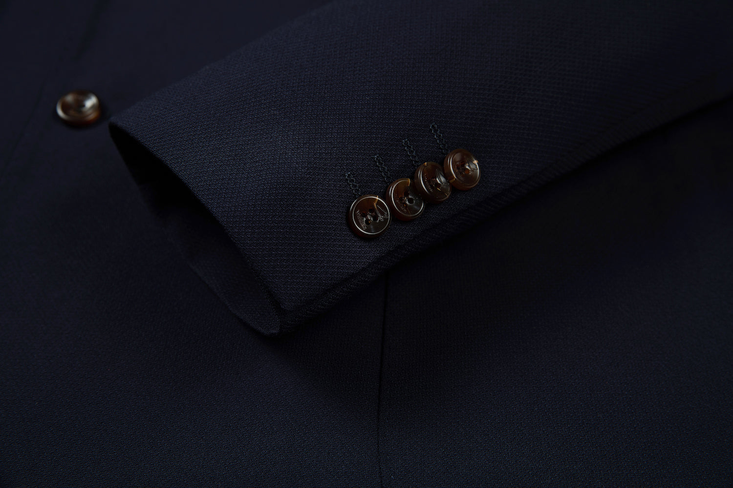 Men's navy double breasted blazer cuff detail - horn buttons with engraved logo on textured fabric