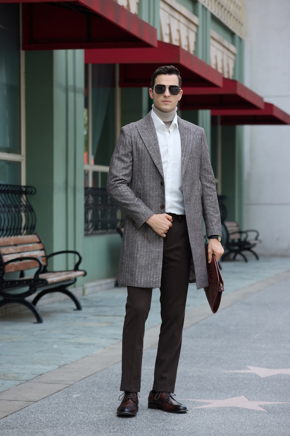 Grey long coat for men – confident street style with leather clutch