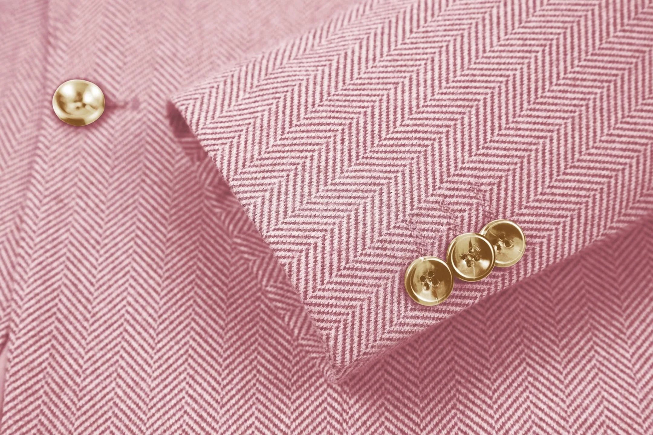 Detailed shot of men's pink herringbone business suit sleeve – showcasing fine tailoring and classic details
