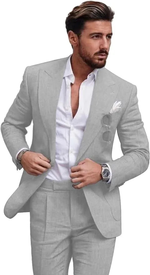 Front view of man wearing light grey slim fit linen 2 piece summer suit with peaked lapel jacket and trousers, styled with white shirt for weddings or prom events.