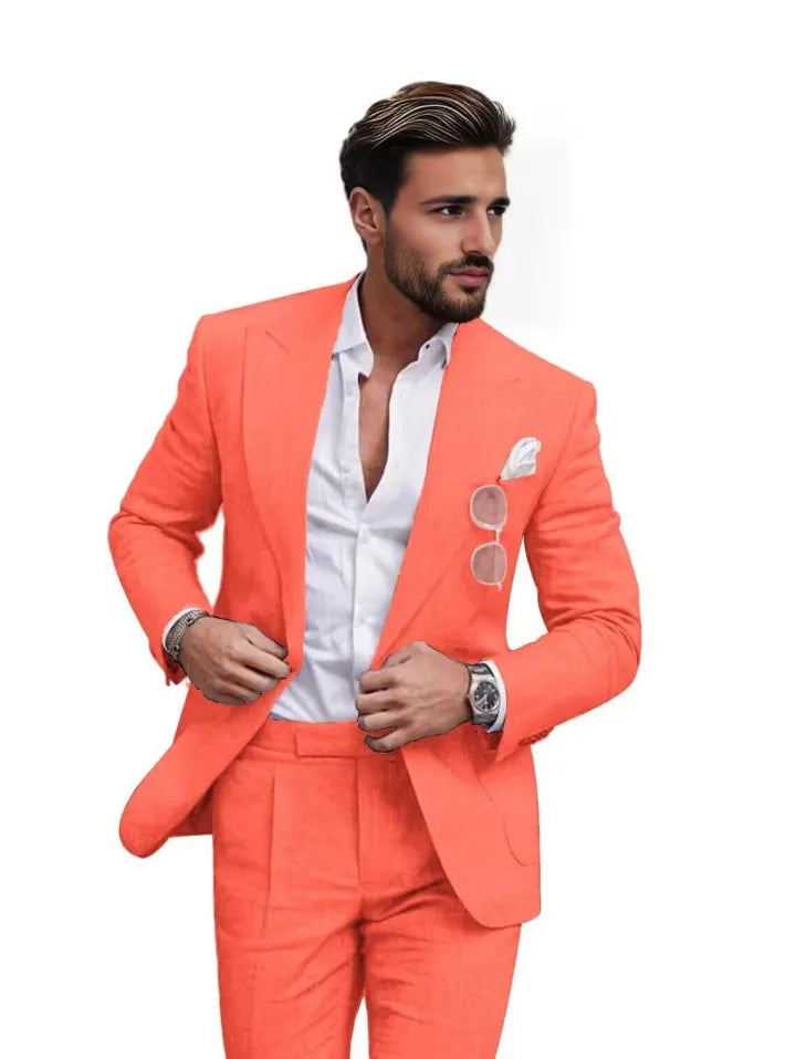 Front view of man in orange red slim fit linen 2 piece summer suit with peaked lapel blazer and trousers, styled for summer weddings.