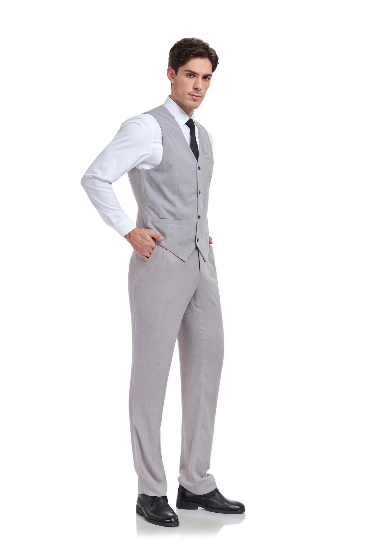 Side view of man in slim fit grey linen 2 piece suit with V-neck vest and trousers, hands in pockets showing relaxed style.
