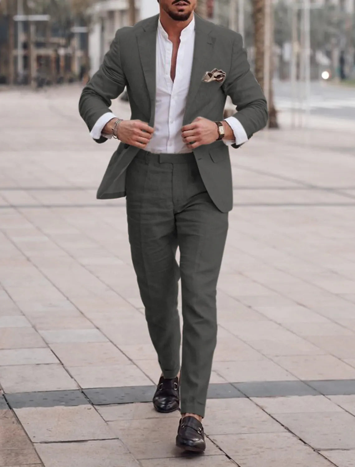 Model in dark gray suit walking on city street in formal casual style
