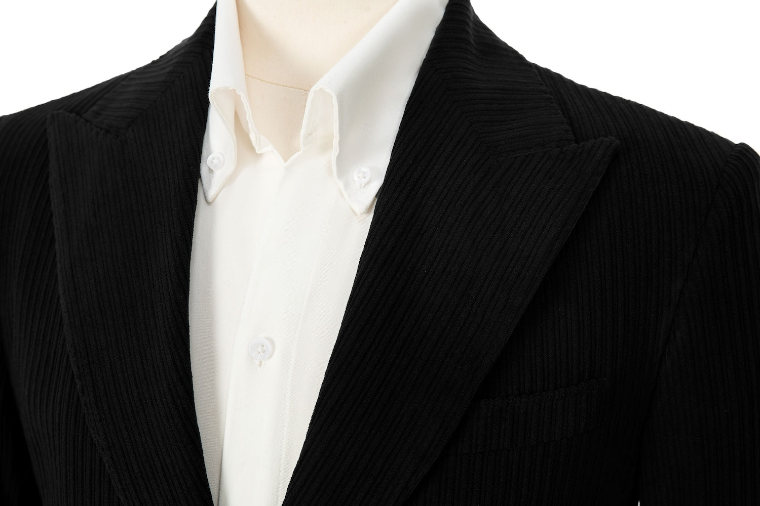 Close-up of black corduroy blazer lapel – textured peak lapel and stitching detail