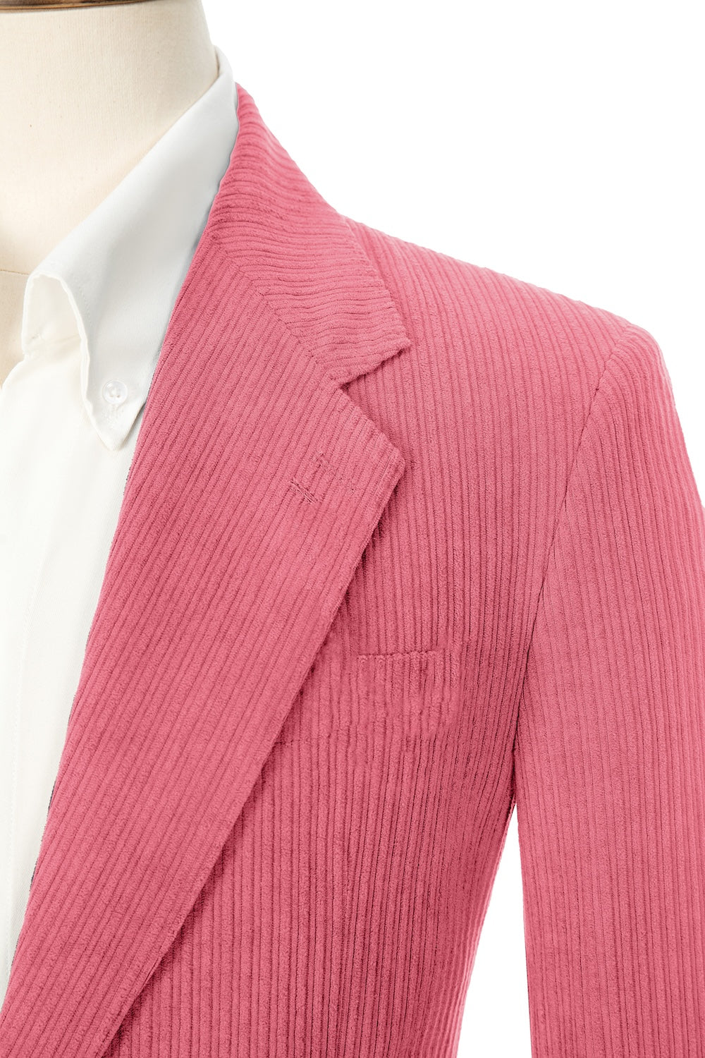 Close-up of hot pink corduroy blazer lapel – textured fabric with clean lines