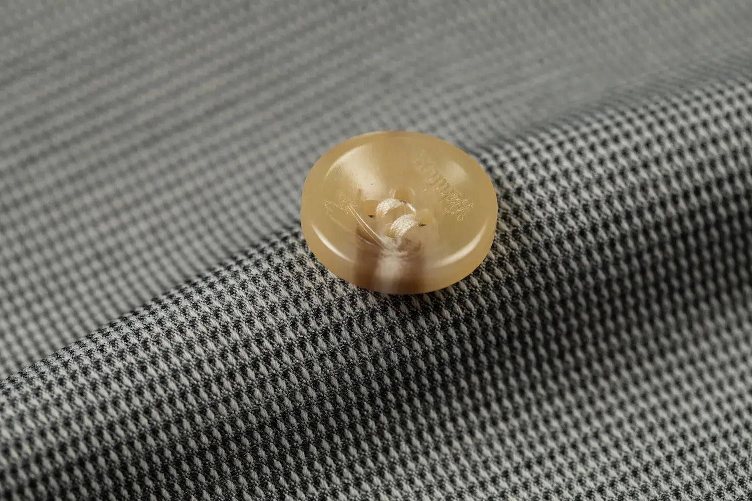 Detail shot of gold button on designer men's plaid blazer