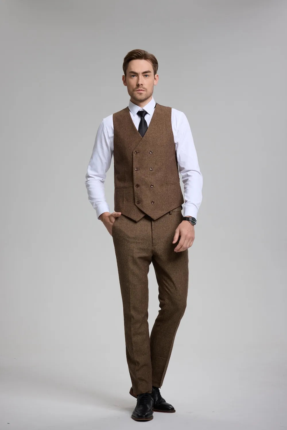 Man in a brown herringbone 3-piece suit waistcoat, paired with tailored trousers and formal accessories.