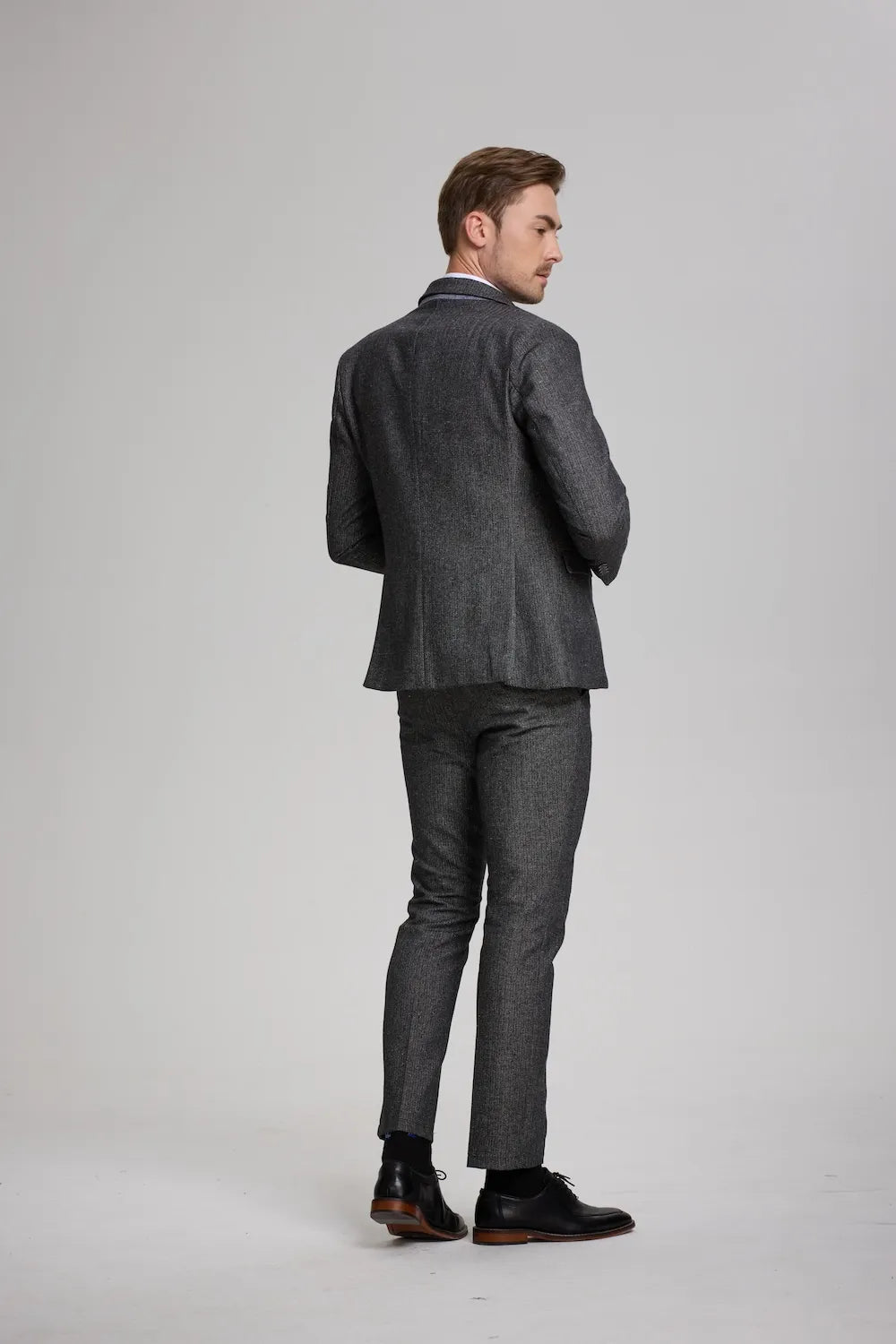 Back view of a dark gray Versatile Herringbone 3-Piece Suit, highlighting the clean lines and sophisticated fit.