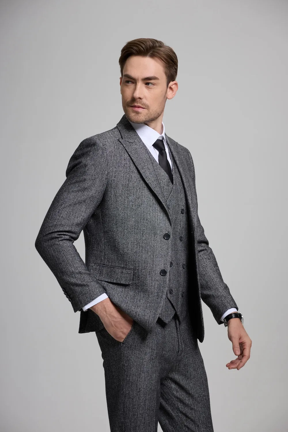 Side view of a dark gray Versatile Herringbone 3-Piece Suit for Men, showcasing sharp tailoring and a modern fit.