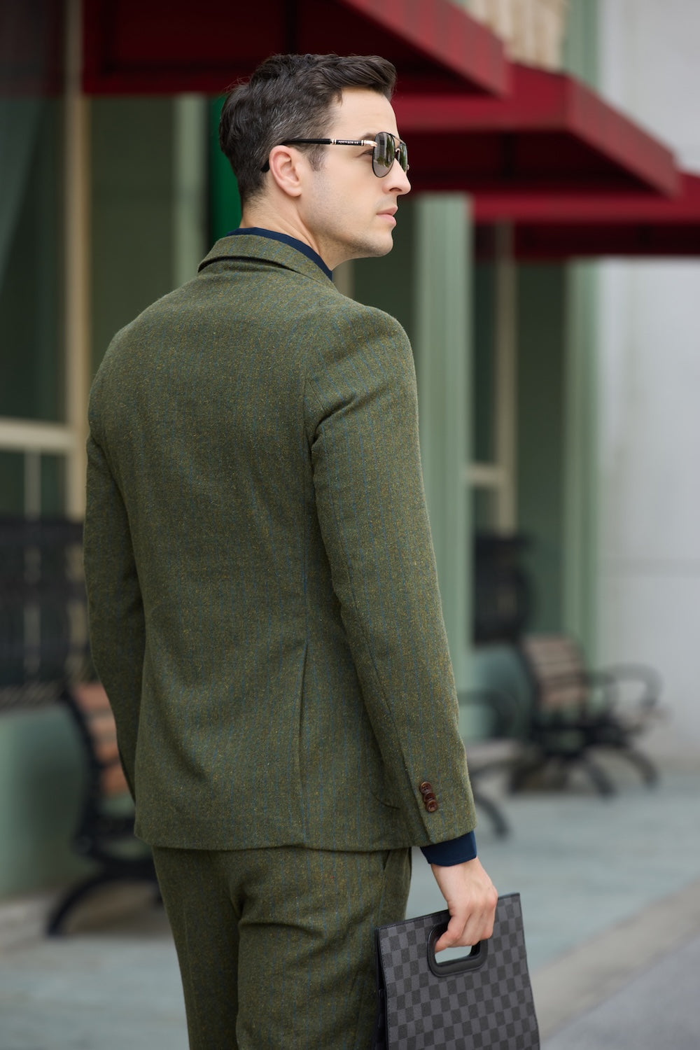 Rear view of green herringbone suit jacket showcasing tailored fit and wool texture