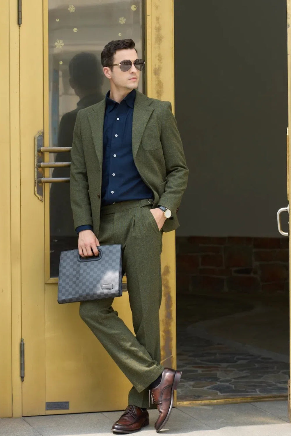 Green herringbone tweed prom suit for men styled with navy shirt and brown shoes
