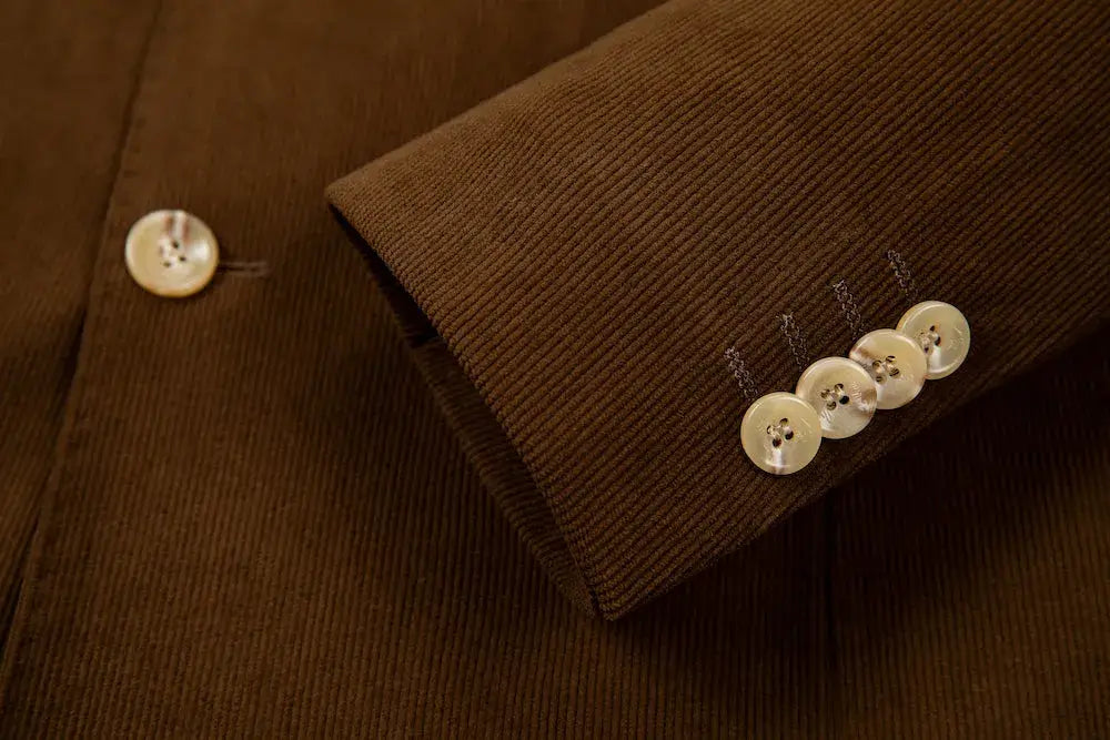 Cuff detail of men's brown corduroy blazer – four-button sleeve with fine stitching and textured finish