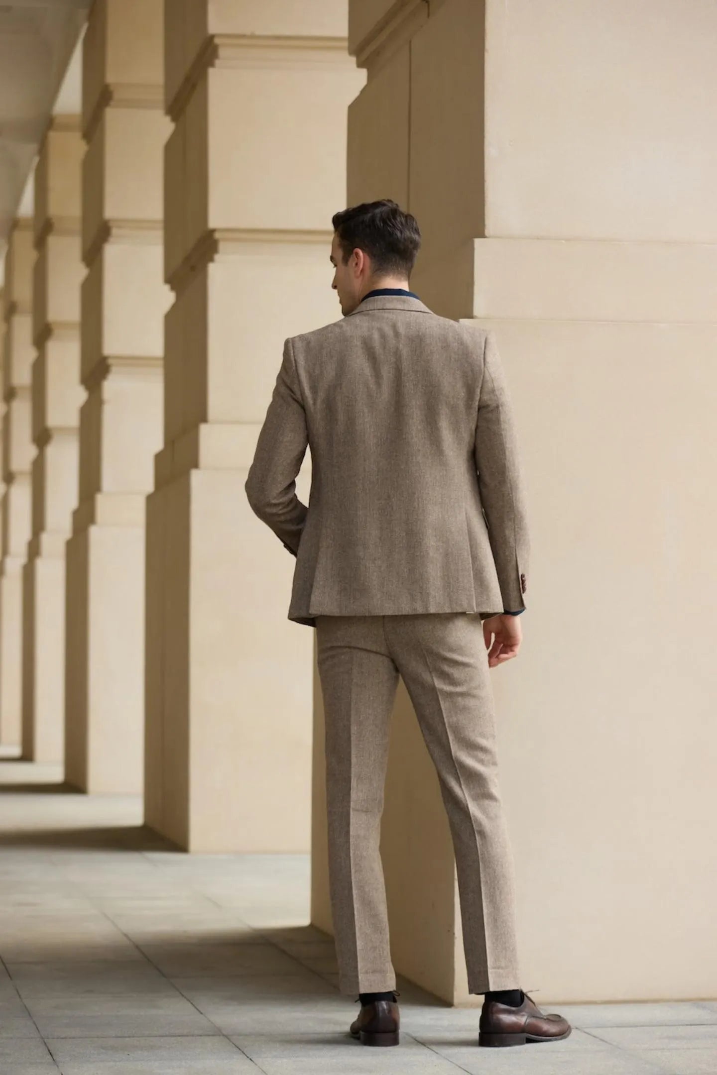 back view of men's light brown tweed herringbone 2 piece suit – slim fit jacket and trousers, ideal for formal business settings.