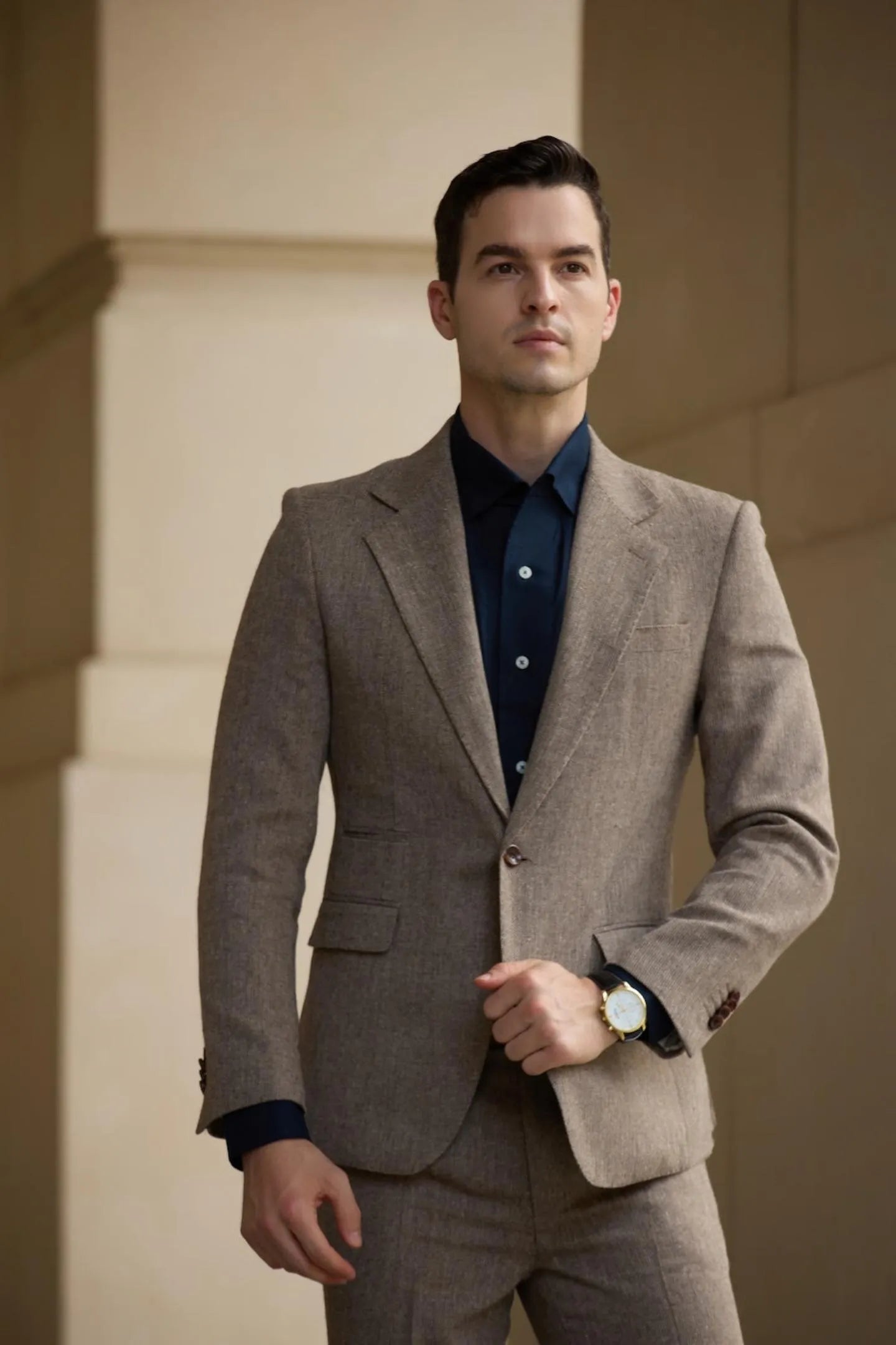 model posing in men's light brown tweed herringbone 2 piece suit – slim fit with jacket and trousers, stylish and professional look.